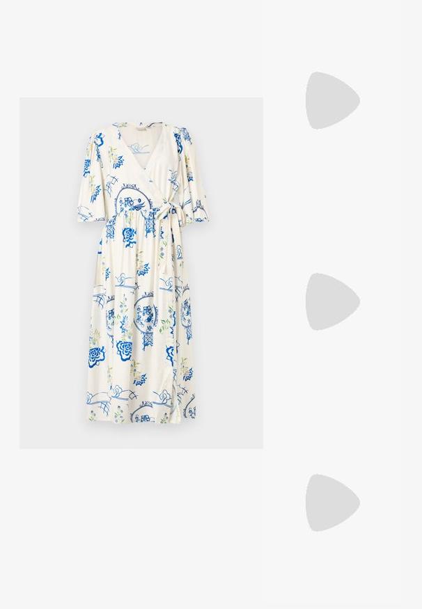 Haljina na preklop u svijetloj krem boji, s plavim cvjetnim uzorcima i zelenim detaljima. Kratki napuhnuti rukavi, detalj s mašnom u struku i dužina do koljena.; Crne kožne pumpe s oštrim vrhom i niskom blok petom. Sadrže remen oko gležnja s zlatnim kopčanjem. Glatka tekstura.; Crna torba s oblikom koji sadrži strukturu, glađu teksturu i metalnu kopču. Uparena s širokim crnim hlačama i sandalama na otvorenom s drvenog poda.; Srebrna metalik kožna jakna s ovčjim krznom, koja ima zatvaranje na patentni zatvarač i teksturiranu površinu. Velike naušnice u obliku suze s prozirnim draguljima.