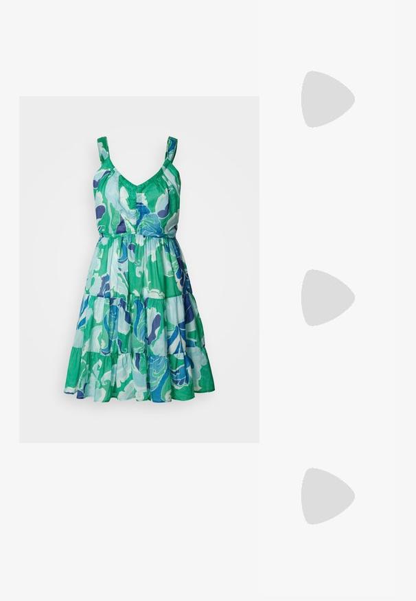 Robe sans manches avec un décolleté en V, jupe superposée, présentant un motif floral vert, bleu et violet sur un tissu léger.; Sandale à talons hauts blanche avec une base de orteil plate, devant texturé avec des accents froncés et une fine bride à la cheville.; Sac en seau argent métallique avec une finition texturée, orné d'une poignée ronde en argent et d'une fermeture à cordon, tenu contre un jean bleu clair.; Boucle d'oreille en argent avec une finition polie, présentant de petits détails en or et de forme ronde, portée sur le lobe.