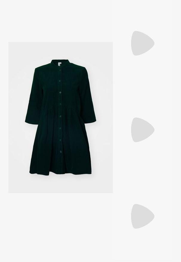 Mørkegrønn kordfløyelskjole med knapper foran, mandarinkrage, trekvartlange ermer og rynket midje for ekstra detaljer.; Sorte patentlær slingback-sko med spiss tå, ankelremmer med sølvspenner og detaljer, og en slank hæl.; Gullfarget metallisk håndveske med en strukturert design, glatt tekstur og justerbar stropp. Har en unik trekantet form og minimalistisk søm.; Gullfargede øredobber med teksturerte, bølgete former. Inkluderer skulpturelle klipsstuds og åpen hoop-design med en hamret finish.