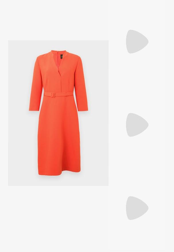 Lys oransje kjole med V-hals og belte i midjen. Har lange ermer og en glidelås bak, laget av glatt, teksturert stoff.; Sorte lærballerina med spiss tå, minimalistisk design, glatt tekstur, lav hæl uten synlig metall eller dekorasjoner.; Metallisk gull clutch med en glatt, rund form, med en toppknapp-lås og et lite kjede for bæring.; Gullfarget ring med en glatt, vridd design. Har en polert overflate og avrundede kanter, som skaper en sømløs, flytende form.