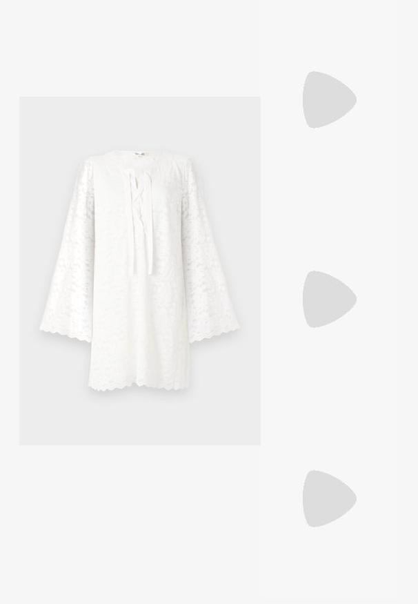 Hvid blonde tunika med rund halsudskæring, lange senepsformede ærmer og en frontknude detalje. Den scalloperede kant tilføjer tekstur og visuel interesse.; Hvid indpakket bluse med lange ærmer, krave og detalje med frynse foran. Lavet af glat stof med en let struktureret design.; Sorte ruskindspointe mules med slanke sorte stropper og en kort stiletto hæl, med en glat læderindersål og uden synlige mønstre.; Guldfarvede hoops øreringe med en buet, uregelmæssig form og en glat, poleret overflade. Ingen synligt hardware eller dekorationer.