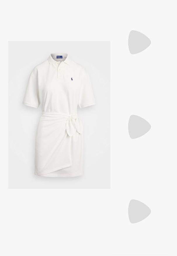 Robe de style polo blanche à manches courtes, avec un détail de nœud à la taille et un logo brodé subtil sur la poitrine.; Baskets en cuir blanc, design bas, avec une texture lisse, bout rond, lacets à l'avant et un petit logo brodé sur le côté.; Sac demi-lune en cuir noir avec des accents en métal doré, doté d'une fermeture éclair. Porté en bandoulière sur un pull gris.; Boucles d'oreilles avec clou en métal doré et design torsadé. Chaque boucle d'oreille est dotée d'un arrière transparent circulaire pour un port sécurisé.
