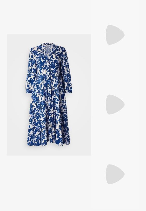 Robe à motif floral bleu et blanc avec des manches longues, décolleté en V, ourlet à volants superposés et texture de tissu douce.; Talons aiguilles blanches à bride arrière avec un bout pointu, un dessus lisse, un petit talon carré et un design avec découpes latérales et sangle réglable.; Lunettes de soleil rondes avec verres sombres et monture en or. Le modèle porte un cardigan à côtes bleu clair avec des boutons et des manches blanches contrastantes.; Porte-monnaie Michael Kors en toile enduite beige avec un motif répété de logo MK, des accessoires en or et une bandoulière en chaîne amovible.