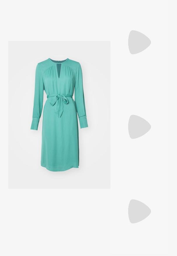 Vestido longo turquesa de mangas compridas com decote em gota, cordão na cintura e punhos abotoados. Tecido suave com uma silhueta ligeiramente drapeada.; Sapato slingback preto em couro, com bico pontudo, salto esguio e acabamento em metal dourado na parte superior. Textura suave e design estruturado.; Bolsa de mão em couro acolchoado preto com uma alça de corrente dourada e um fecho de pressionar com um canto circular. Formato retangular compacto.; Brincos de argola em acrílico transparente com detalhes em metal dourado e um acabamento polido. Apresentam um design circular suave.