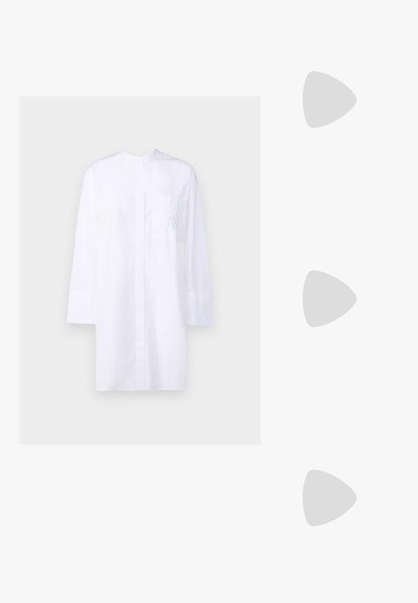 Weiße Bluse mit langen Ärmeln, einer Fronttasche mit subtiler blauer Stickerei und einem klaren, minimalistischen Design.; Weiße Sandale mit Absatz und quadratischer Zehenpartie, zwei schlanken Riemen und einem Schnallenknöchelriemen; glitzernde silberne Akzente am Absatz.; Schwarze Lederhandtasche mit Fransen-Details, goldener Ketten-Schulterriemen und einem ausgeschnittenen Griff. Mit Logoplatzierung auf der Vorderseite.; Goldtonige Ohrringe mit mehreren kaskadierenden Ketten, verziert mit klaren ovalen Strasssteinen und dekorativen Ohrsteckern.