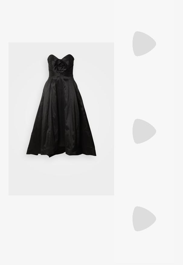 Rochie neagră fără bretele, cu o aplicație florală la bust, fustă plisată și o siluetă fluidă. Material asemănător satinului, textură netedă.; Sandale negre cu toc înalt au curele subțiri cu un design legat, un vârf pătrat neted și un toc stiletto elegant.; Geantă metalică gri deschis, cu un strap din lanț, decorată cu mici ținte circulare metalice și un logo de marcă triangular.; Cercei rotunzi din argint cu un finisaj neted și strălucitor. Design ușor, având o formă rotundă și închidere cu tijă.