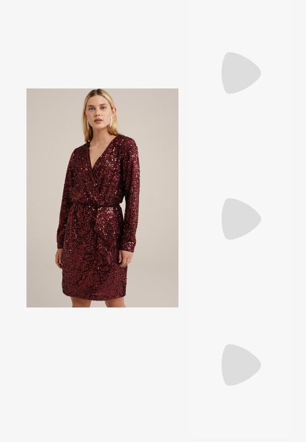 Punane sädelev kleit, millel on pikad varrukad ja V-kujuline kaelus, ning millel on vöö taljejuures, et rõhutada figuuri.; Must mustaapp, millel on terav nina ja madal blokk-kand. Omab pahkluu rihma koos kuldse tooni pandlaga. Sile tekstuur.; Mustad ümarad päikeseglaasid, millel on gradient objektiivid, paksud raamid ja kuldse tooni kettaga kaunistused tempelitel.; Must musta kott, millel on struktureeritud kuju, sile tekstuur ja metallist klamber. Kombineeritud laiate mustade pükstega ja avatud varvaste sandaalidega puidust põrandal.