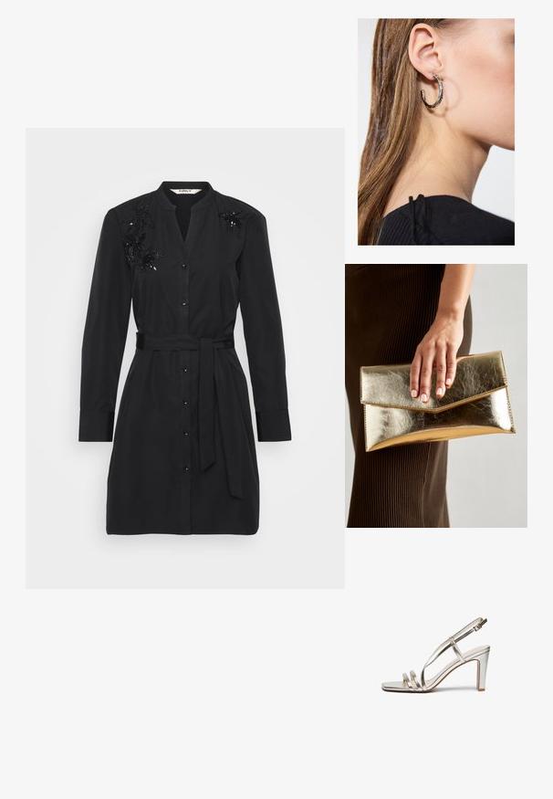 Abito camicia nero in cotone con cintura in vita, chiusura frontale a bottoni e dettagli floreali in paillettes sulle spalle.; Sandaletta con tacco alto in argento metallico e punta aperta, dotata di tre sottili cinturini sul piede e di una cinghia alla caviglia con fibbia.; Borsa a mano metallic oro con una texture liscia, dotata di una chiusura a pattina triangolare. La mano che la tiene ha unghie curate.; Orecchino a cerchio in argento con finitura lucida, caratterizzato da piccoli dettagli in oro e una forma tondeggiante, indossato sul lobo.