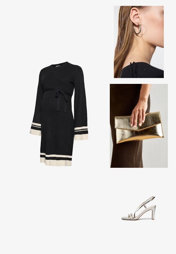 Vestido de maternidade preto canelado com mangas compridas, cinto ajustado na cintura e riscas brancas nos punhos e na bainha. Textura suave.; Sandal de salto alto prateado metálico com biqueira aberta, apresentando três tiras finas sobre o pé e uma tira no tornozelo com fivela.; Bolsa de mão metálica dourada com uma textura suave, apresentando um fecho em aba triangular. A mão que a segura tem unhas bem cuidadas.; Brinco de argola prateada com acabamento polido, apresentando pequenos detalhes em dourado e uma forma redonda, usado na orelha.