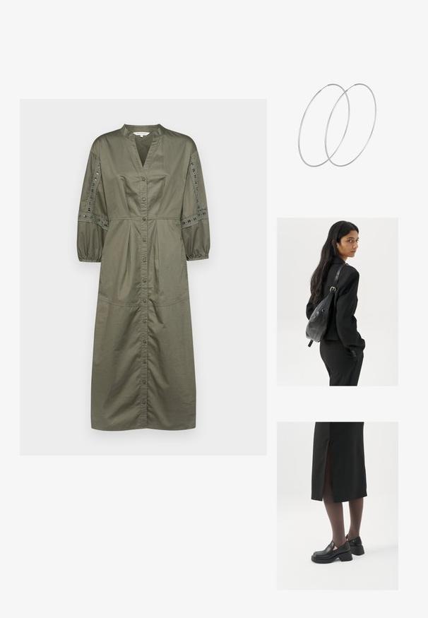 Olivenfarbenes, knöpfbares Kleid mit V-Ausschnitt, gerafften Ballonärmeln und Spitzenverzierungen an den Ärmeln. Aus Baumwollstoff, in Midilänge.; Schwarze Lederschuhe mit abgerundetem Zeh, dicker Blockabsatz und elastischen seitlichen Akzenten, kombiniert mit dunklen Strumpfhosen und einem schwarzen Rock mit Schlitz.; Frau mit langen dunklen Haaren, die einen schwarzen Anzug trägt und eine schwarze Lederschultertasche hält, schaut über ihre Schulter vor einem weißen Hintergrund.; Silberne Creolen mit minimalistischem Design. Rundform, glatte Oberfläche und dünnes Profil. Leichtgewichtig mit hochglänzender Oberfläche.