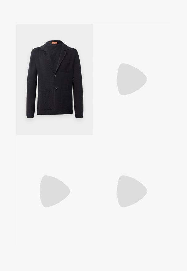 Blazer en maille noire avec un motif en chevrons, revers cranté, deux poches avant et deux boutons. Étiquette visible à l'intérieur du col.; T-shirt en coton blanc avec un motif zigzag multicolore sur le devant. Col rond et manches courtes. Détail du logo sous le motif.; Pantalons évasés noirs en tissu mélangé coton, dotés d'une fermeture à bouton, de passants de ceinture et d'une texture lisse sans motifs visibles.; Mocassins en cuir noir avec un bout arrondi, un talon bas et une semelle en caoutchouc épaisse et texturée. Présente un accent cousu et un petit logo sur le côté.