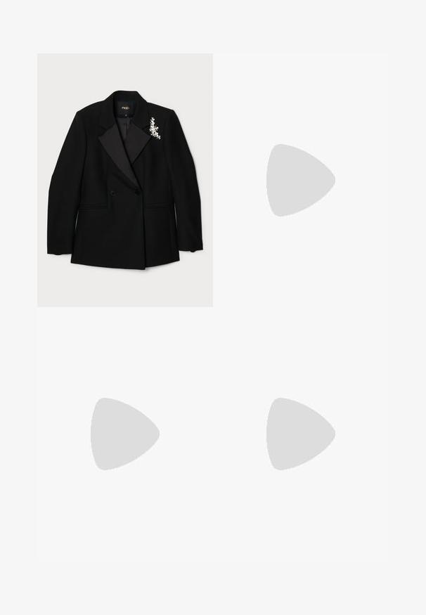 Maje Blazer - noir; Body bianco senza maniche realizzato in tessuto a costine, con scollatura a onde e dettaglio di apertura sul retro, oltre a un design della parte inferiore affusolato.; Pantaloni neri a zampa d'elefante con ricami decorativi in foglia d'argento all'orlo. Presentano un tessuto liscio, una vestibilità sagomata e un design frontale piatto.; Scarpa slingback nera in pelle con punta affusolata, cinturini decorativi con occhielli metallici e tacco basso a blocco. Superficie testurizzata.