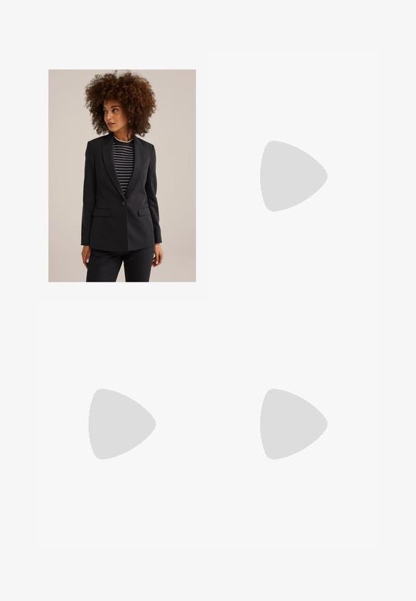 Femme avec des cheveux bouclés portant un blazer noir ajusté sur un haut rayé noir et blanc, regardant sur le côté face à un fond uni.; Chemise noire à manches longues avec un large col, en tissu doux, présentant une coupe ajustée et de minimalistes détails de couture.; Jean flare en denim bleu avec une taille haute, une quincaillerie dorée au niveau de la ceinture, et un délavé pour un aspect texturé distinct.; Mocassin en cuir marron avec un bout rond, détail doré sur le dessus, et un petit talon en bois solide. Texture lisse.; Montre-bracelet rectangulaire dorée avec un cadran blanc, des index horaires argentés et un bracelet en métal durable. Fonction étanche incluse.