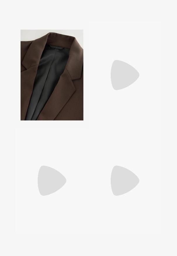 Brun blazer med et glat, struktureret stof. Den har en spidse krave og en sort, stribet inderside. Simpelt, rent design.; Sort tanktop med tynde stropper, ribbet overflade og scoop-udskæring. Materialet fremstår blødt og tætsiddende, med minimale sømme og uden mønstre.; Sorte brede bukser lavet af blødt stof, med høj talje og en glat tekstur, der har rene linjer og ingen synlige lukninger.; Brune ruskind sneakers med hvide detaljer og snørebånd. Gummisål i naturgummi. Båret med hvide sokker med sorte striber. Grøn struktureret gulv.; Skildpaddevmønster solbriller med rund form og lys linse. Har solide arme med små guld accenter, lavet af plastmateriale.