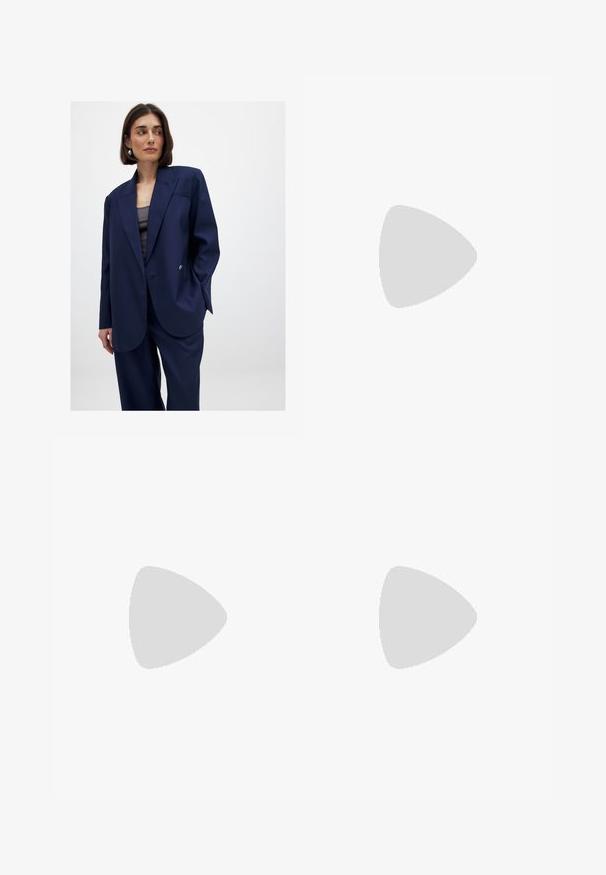 Blazer oversize blu navy realizzato in tessuto liscio, presenta una chiusura con un solo bottone, rever a punta e un sottile dettaglio della tasca sul petto.; Abito a maglia blu a coste con maniche lunghe, polsini svasati e scollatura arricciata. Silhouette aderente che si estende a un orlo arricciato. Scarpe nere.; Top a canotta bianco a coste con scollatura rotonda e senza maniche, caratterizzato da un orlo dritto e una texture liscia e elastica.; Infradito neri con suola in gomma testurizzata, due cinghie sottili e un sottile dettaglio del logo impresso sulla cinghia.