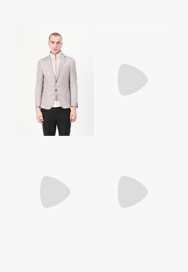 Blazer gris clair avec une finition texturée, doté de deux poches avant et d'une fermeture à boutons, superposé à un vêtement crémeux à col haut.; T-shirt en coton rouge à manches courtes, col rond, avec un petit logo de crocodile vert sur la poitrine gauche. Texture lisse, coupe décontractée.; Samsøe Samsøe JOHNNY TROUSERS  - Pantalon classique - black; Baskets Lacoste en gris foncé, en matériau mesh et synthétique, avec une semelle texturée et des accents marron sur le col et le branding.