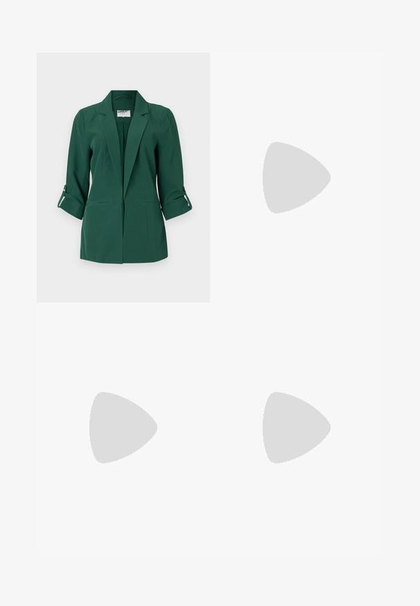Grønn skreddersydd blazer med krage, frontlommer og oppbrettede mansjetter. Laget av glatt stoff med en strukturert design.; Svart oversized t-skjorte med en grafikk av en bjørn og teksten "IKKE SØT, MEN VILL" i fet, hvit skrift. Laget av bomull.; Lyseblå høytlivsjeans laget av denim. Har vide bein, to revne knær og klassisk fem-lommers design.; Hvit høy-skinn kanvas sneakers med svart gummisåle, gummitåhette foran og seks hull for snorer, med et rent, minimalistisk design.