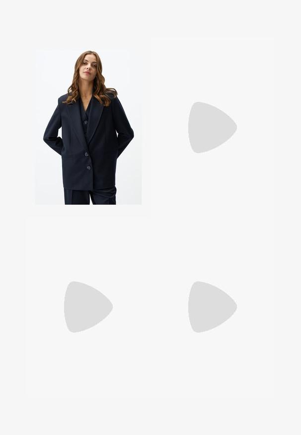 Blazer navy con design doppiopetto, rever a punta e due tasche frontali. Realizzato in tessuto liscio, presenta tre bottoni grandi.; Top bianco senza maniche con scollo rotondo, caratterizzato da una sottile trama, dettaglio a rombo sul retro e orlo dritto.; Jeans bianchi a gamba larga in denim, caratterizzati da un'alta vita, design a cinque tasche e chiusura con bottone metallico. Tessuto liscio, senza fantasie.; Infradito con suola in gomma color talpa, progettate con tre cinturini in pelle bianca sovrapposti e un piccolo dettaglio a fiocco al centro.; Borsa in pelle grigio chiaro con design a forma di U e manico metallico curvo. Texture liscia con cuciture minime e senza motivi visibili.