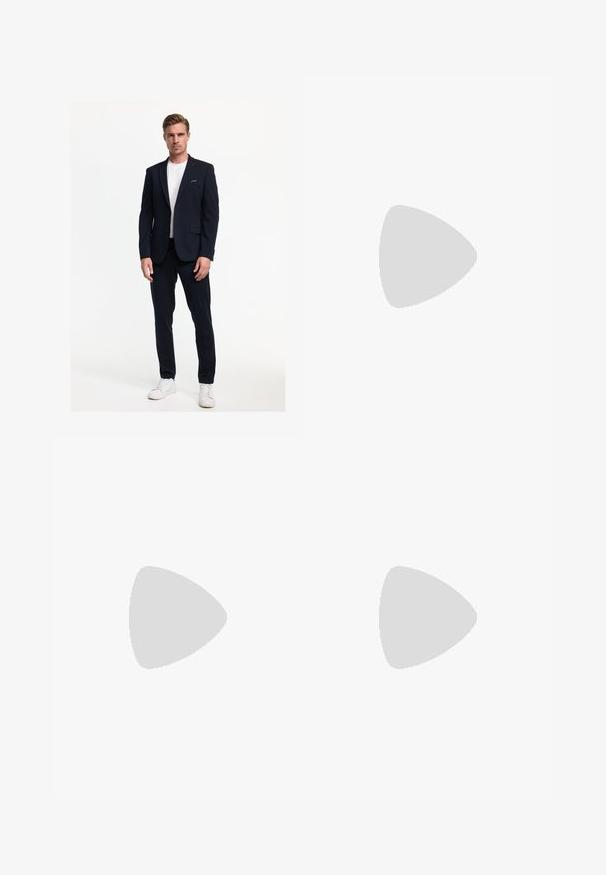Giacca da abito blu navy con due bottoni e collo a scendere, abbinata a pantaloni coordinati e una maglietta bianca, completata da sneakers bianche.; Camicia azzurra a maniche lunghe con colletto classico, orlo dritto e una trama sottile. Presenta una chiusura centrale con bottoni.; Pantaloni in lino verde oliva con piega frontale, dotati di chiusura con bottone e una fodera a quadretti a contrasto nella cintura.; Mocassini sintetici neri con una spessa cucitura frontale, soletta imbottita e suola piatta in gomma; design elegante con dettagli minimi.