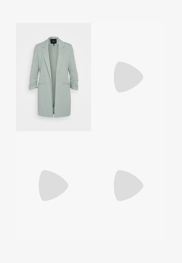 Vero Moda VMRICA LONG - Blazer - jadeite; T-shirt nera in cotone con maniche corte sopra un sotto manica lunga bianca, caratterizzata da una sottile texture. Design con scollo rotondo.; Pantaloni neri a plissé con vita elasticizzata. Presentano gamba ampia e un tessuto liscio e texture con strisce verticali.; Pump in pelle nera con punta affusolata, cinturino alla caviglia e tacco spesso. Texture piatta, design elegante ed estetica minimalista.