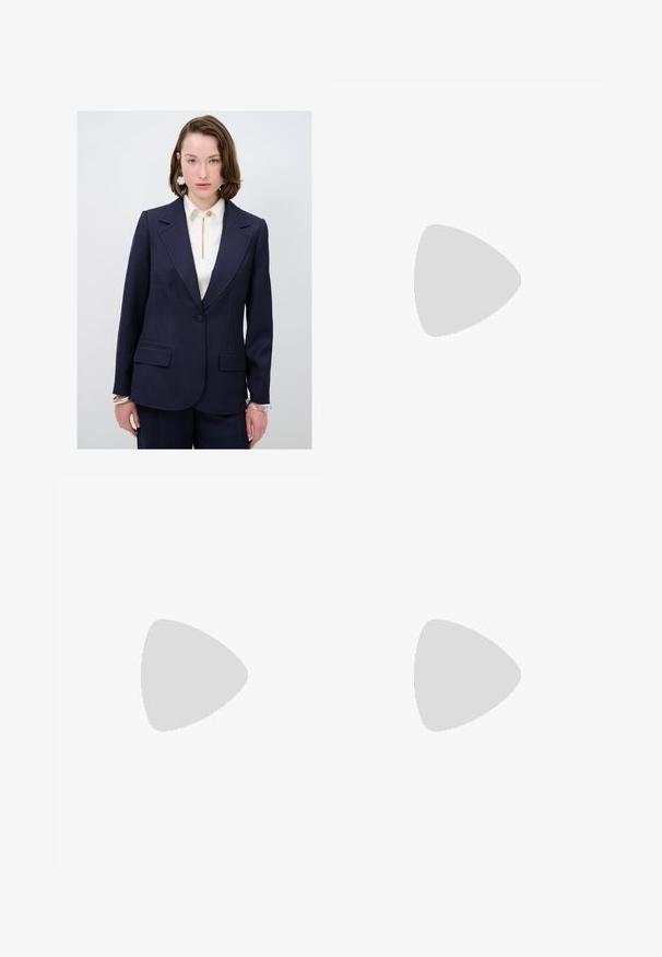 Blazer tailored color navy con rever a taglio, due tasche frontali e dettagli di cucitura blu discreti. Abbinato a una blusa crema con apertura a chiave.; Costume da bagno intero marrone con collo alto e spalline sottili e regolabili; presenta una gamba alta e una texture liscia. Nessun motivo o decorazione.; Pantaloni neri a gamba dritta, con tasche frontali e spacchi laterali all'orlo. Realizzati in tessuto morbido e liscio. Adatti a diverse occasioni.; Sandalo con tacco aperto nero, con cinturini incrociati, fibbia regolabile alla caviglia e tacco spesso, con una texture in pelle liscia.; Borsa nera con forma strutturata, texture liscia e una chiusura metallica. Abbinata a pantaloni neri larghi e sandali open-toe su un pavimento in legno.