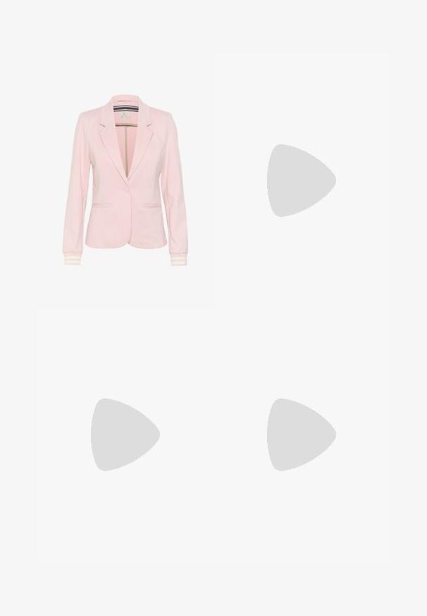 Lichtroze blazer gemaakt van zachte stof, met een notch-kraag, twee voorzakken, een enkele knoopsluiting en gestreepte mouwboorden.; Witte fitted top van ribstof met korte mouwen en geplooide details aan de zijkanten voor textuur en vorm.; Witte wijde broek gemaakt van een lichte stof. Voorzien van een elastische tailleband met een trekkoord en zijzakken. Zachte textuur.; Lichtroze suède sneakers met witte strepen en veters, voorzien van een gestructureerde tong en een gumzool, geplaatst op een blauwe tapijt.