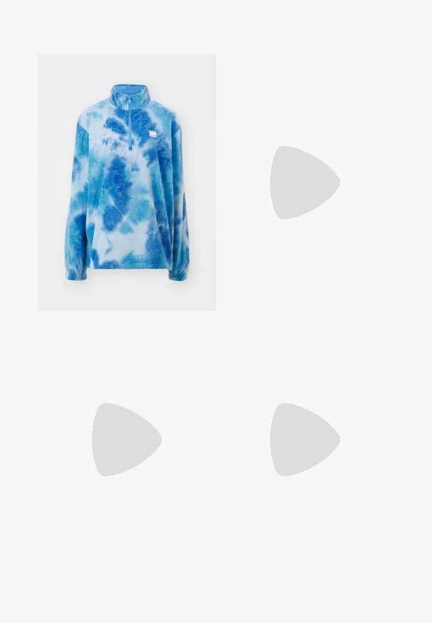Pulover od flisa s ovratnikom na patent, s plavim tie-dye uzorkom. Meka tekstura, duge rukave i mali logo na prsima.; Bijeli crop top s cvjetnim uzorkom, bež hibiskus cvjetovima i izvezenim "Roxy" logom u tamnocrvenoj boji. Ima dizajn sa halter vratom.; Plave tie-dye trenirke izrađene od mekog materijala, s elastičnim pojasom i rebrastim manžetama. Labav kroj u različitim nijansama plave boje.; Crne nubuk tenisice s bijelim šavovima i prepoznatljivom bočnom prugom, s bež gumiranim potplatom i niskim dizajnom. Zavezane crnim vezicama.