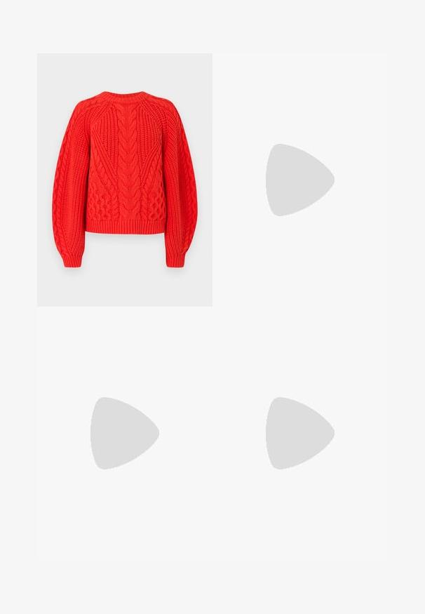 Rød kabelstrikksweater med teksturerte mønstre, rund hals og ribbestrikket kant. Designet med lange, svakt puffede ermer.; Brune høyhælte, vide bukser med frontfold og skjult glidelås foran.; Svarte patent lær slingback hæler med spiss tå og en liten blokkheel, med en sølvspenne som detalj på stroppen.; Hvit rektangulær clutch-veske laget av blankt materiale, med en sølvkjede-stropp. Modellen poserer og viser vesken mot en ensfarget bakgrunn.