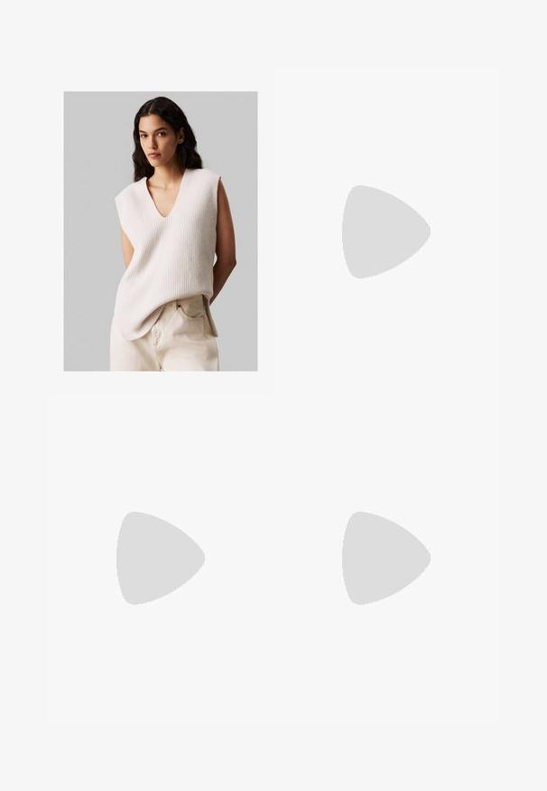 Femme avec de longs cheveux noirs portant un pull en tricot crème sans manches avec un décolleté en V et un pantalon taille haute beige clair, se tenant devant un fond gris uni.; Pantalons à jambes larges en tissu marron, avec une ceinture à boucle carrée, un design plissé et une texture lisse.; Escarpins à talons slingback noirs à bout pointu avec une finition brillante, talon fin et design à dos ouvert. Motif texturé sur le matériau supérieur.; Sac à main en cuir noir avec une texture lisse. Dispose d'une bandoulière adjustable et d'un design élégant et minimaliste avec une fermeture éclair.