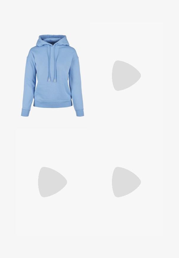 Világoskék kapucnis pulóver, puha anyagból készült, zsinóros kapucnival, bordázott mandzsettákkal és aljjal, lazán illeszkedik és minimális részletezéssel bír.; Fekete, oversized póló, rajta egy medvével és a "NEM CUKI, HANEM FÉKTELEN" felirattal vastag, fehér betűkkel. Pamut anyag.; Világoskék, magas derekú farmernadrág. Széles lábakkal, két szakadt térddel és klasszikus öt zsebes dizájnnal rendelkezik.; Fehér magaskorsó vászon sportcipő fekete gumi talppal, elülső gumi orrnyereggel és hat fűzőlyukkal, letisztult, minimalista dizájnnal.