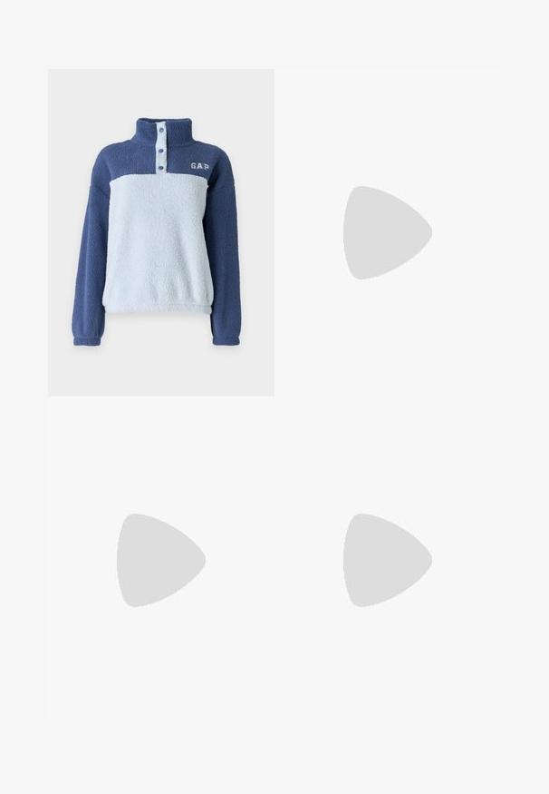 Mikina z fleece v dvoch odtieňoch modrej s vysokým golierom, čiastočným zapínaním na gombíky a bielym logom "GAP" na ľavej strane hrude.; Čierne skrátené tričko z bavlny, s krátkymi rukávmi, okrúhlym výstrihom a malým bielym logom na ľavej hrudi.; Džíny s širokými nohavicami vyrobené z stredne ťažkej modrej bavlnenej tkaniny. Majú klasický dizajn s piatimi vreckami a zips s gombíkovým zapínaním.; Biele kožené tenisky s béžovými semišovými akcentmi, perforovanou špičkou, plochými šnúrkami a textúrovanou krémovou podrážkou. Obsahujú jemné označenie na päte.