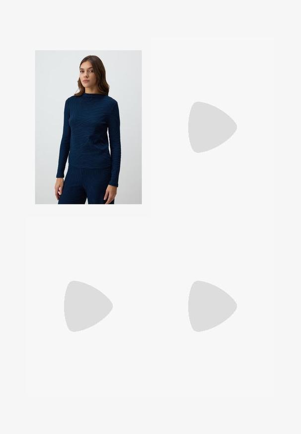 Top a maniche lunghe blu navy con un design a motivo onda testurizzato. Il tessuto sembra morbido e leggermente aderente, con scollo a giro.; Pantaloni culotte neri in poliestere con una cintura elastica, due pieghe frontali e una silhouette ampia. Nessun motivo visibile o dettagli in metallo.; Décolleté in vernice nera con punta affusolata e tacco in geometria cubica. Presentano un design elegante e minimalista, con una texture liscia.; Borsa in denim con forma curvata, colore azzurro chiaro, tracolla regolabile e una piccola pochette staccabile con accenti metallici.