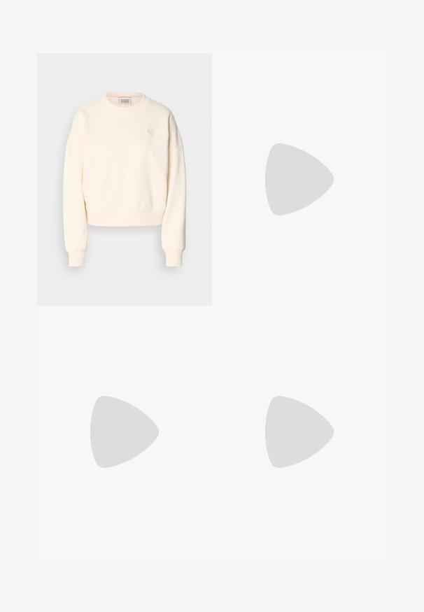 Sweatshirt court crème avec un col rond, des poignets côtelés et un logo brodé discret sur la poitrine. Tissu à la texture douce.; Jeans en denim bleu à taille haute et jambes larges avec un lavage dégradé, des coutures cuivrées, une fermeture à bouton à l'avant et cinq poches.; Ballerines slingback rose pâle avec un bout pointu, fabriquées en un matériau semblable au cuir lisse. Présentent des découpes sur les côtés et un talon plat.; Sac à main noir à la forme structurée, texture lisse et fermoir métallique. Associé à un pantalon noir ample et des sandales ouvertes sur un sol en bois.