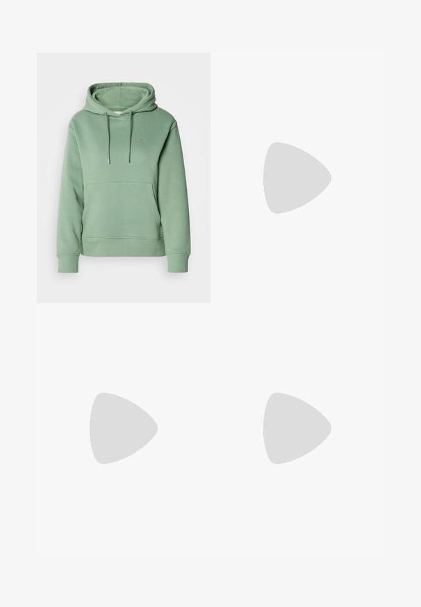 Hoodie en coton vert avec une poche avant, une capuche à cordon et des poignets côtelés. Présente un petit logo brodé sur la poitrine.; Jeans large bleus clairs en denim, avec une taille haute, un lavage décoloré et un motif tie-dye subtil à l'avant.; Baskets basses blanches avec un tab de talon noir, semelle plateforme, lacets et logo "CK" de Calvin Klein sur le côté.; Boucles d'oreilles en argent en forme de créole avec un design texturé comportant des rayures verticales. Forme circulaire avec un fermoir à attache sécurisée. Fini lisse.