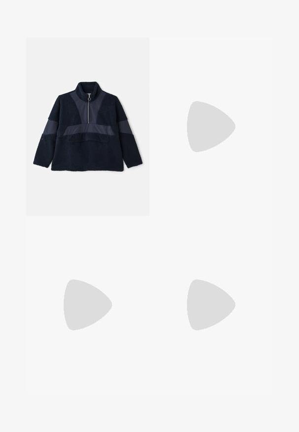 Marine fleece pullover met een hoge kraag, halve rits en contrasterende gladde stofpanelen. Zachte textuur en relaxte pasvorm verhogen het comfort.; Witte katoenen t-shirt met korte mouwen, ronde hals, relaxte pasvorm en zonder zichtbare logo's of patronen. Gladde textuur en minimalistisch ontwerp.; Hoge taille, losvallende jeans van vervaagd zwart denim. Beschikt over vijf zakken, riemlussen en een schone, rechte broekspijp ontwerp.; Grijze en witte sneaker met een bovenwerk van suede en leer, ronde neus, platte veters en een rubberen zool met een gumaccent.