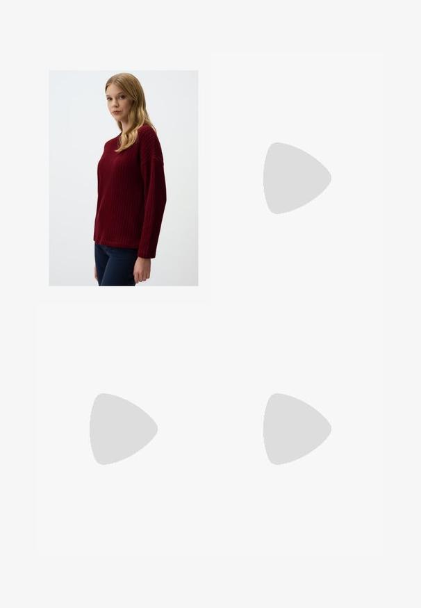 Maglione lavorato a maglia bordeaux con un motivo testurizzato, scollo a girocollo e spalle scese, abbinato a pantaloni blu scuro.; Pantaloni neri a gamba larga con pieghe, caratterizzati da una texture liscia e un design a vita alta. Stile minimalista, senza hardware o decorazioni visibili.; Sandalo bianco con tacco alto, caratterizzato da un design a cinturini e un legaccio alla caviglia. Texture liscia con una piattaforma frontale per un'altezza aggiuntiva.; Borsa tote in pelle nera con texture liscia, forma rettangolare e due manici lunghi. Nessun hardware o decorazione visibile.