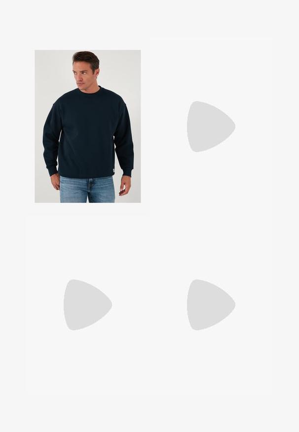 Felpa blu navy con collo rotondo, maniche lunghe, vestibilità comoda, colletto e polsini ribattuti, realizzata in morbido materiale misto cotone.; Maglietta a maniche lunghe con righe orizzontali blu navy e bianche, colletto tondo, in cotone e dalla vestibilità comoda.; Jeans in denim blu a gamba larga con lavaggio sbiadito, design a cinque tasche e chiusura con bottone. Dotati di passanti per cintura e dettagli cuciti.; Sandalo marrone a due cinturini con fibbie in tono rame, plantare in sughero e suola in gomma. Design elegante con cinturini regolabili per una vestibilità ottimale.; Collana d'argento con ciondolo circolare decorato con un motivo di onda e leone, texture dettagliata e una catena con maglie alternate lisce e testurizzate.