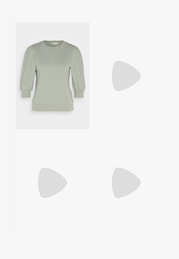 Pullover verde chiaro realizzato in morbido tessuto, con maniche a sbuffo, scollo rotondo e polsini e orlo a coste. Finitura liscia e texturizzata.; Pantaloni a coste grigi in maglia, con gamba ampia e vita elasticizzata. Il tessuto ha un aspetto textured, offrendo una vestibilità comoda.; Sneaker bianco realizzato in materiali mesh e pelle, con punta arrotondata, suola spessa, lacci prominenti e marchio sul tallone e sulla linguetta.; Occhiali da sole quadrati in tartaruga con lenti gradientate marroni, caratterizzati da dettagli dorati sulle tempie e una montatura spessa e lucida.