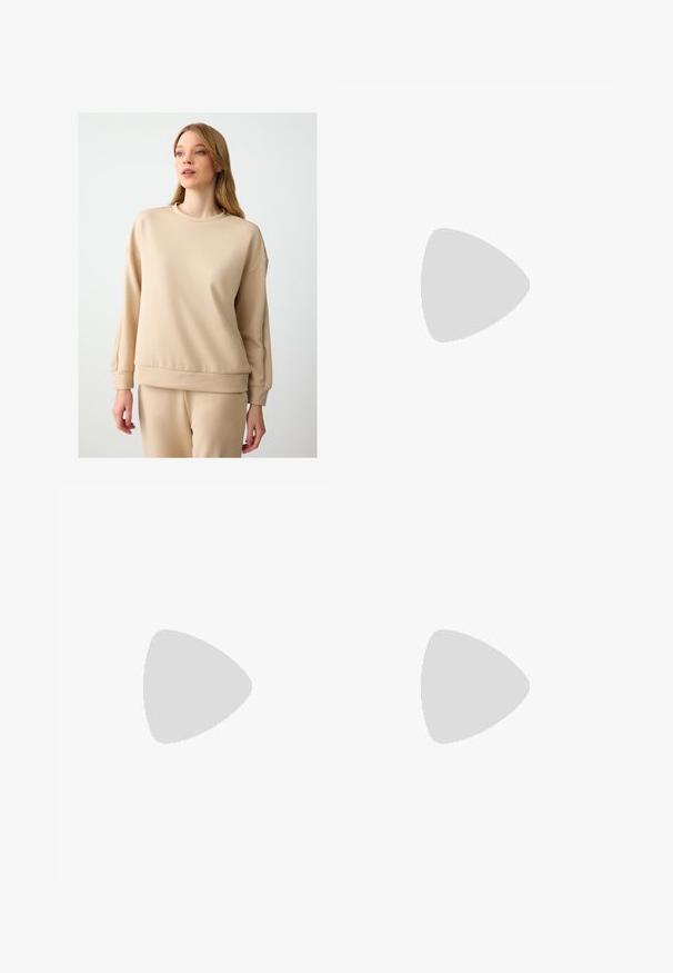 Beige sweatshirt with a textured finish, round neck, and dropped shoulders. A minimalist design features subtle seam details and ribbed cuffs.; Black leather trousers with a smooth texture, featuring a straight fit, two front pockets, and visible seam detailing.; Black leather pump with a pointed toe and a low block heel. Features an ankle strap with a gold-tone buckle. Smooth texture.; Black leather tote bag with two long handles, a smooth texture, and a structured shape. Features a front pocket for additional storage.