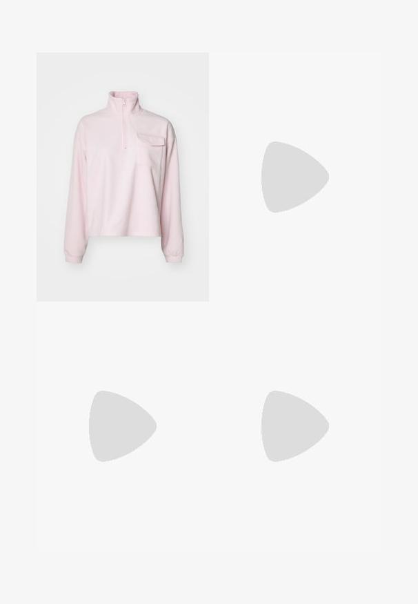 Fleece pullover in zacht roze, met een hoge kraag, een halve rits en een borstzak. Lange mouwen met aansluitende manchetten. Soepele textuur.; Lichtblauwe denim wijde-lange jeans met een hoge taille, voorzien van een vervaagde wassing en kleine, verspreide versleten details overal.; Witte sneakers met zwarte strepen en beige suède accenten. Voorzien van een gestructureerde gumzool en platte witte veters, gedragen met lichtgekleurde sokken.; Zwarte laarzen in lakleer met een gebogen vorm, één schouderband, voorvakken en accenten in zilverkleurig metaal.