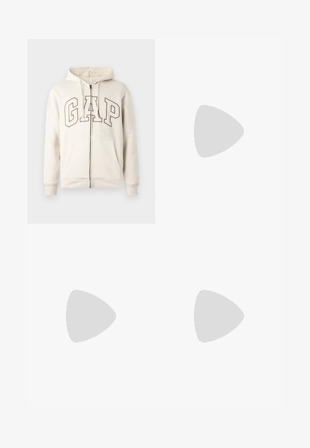 Felpa con zip beige, con cappuccio foderato in pile, cordini, tasche frontali e grandi lettere "GAP" contornate sul petto.; T-shirt bianco in cotone con maniche corte e colletto a girocollo. Il testo centrato recita "BENVENUTO IN PARADISO" in un font verde curvo.; Pantaloni cargo bianchi con vestibilità rilassata, chiusura frontale con bottone e molteplici tasche laterali, realizzati in materiale di cotone resistente.; Sneakers bianchi dalla texture liscia, con dettagli in pelle marrone e particolari neri, abbinati a pantaloni neri su misura. Sfondo in parquet.