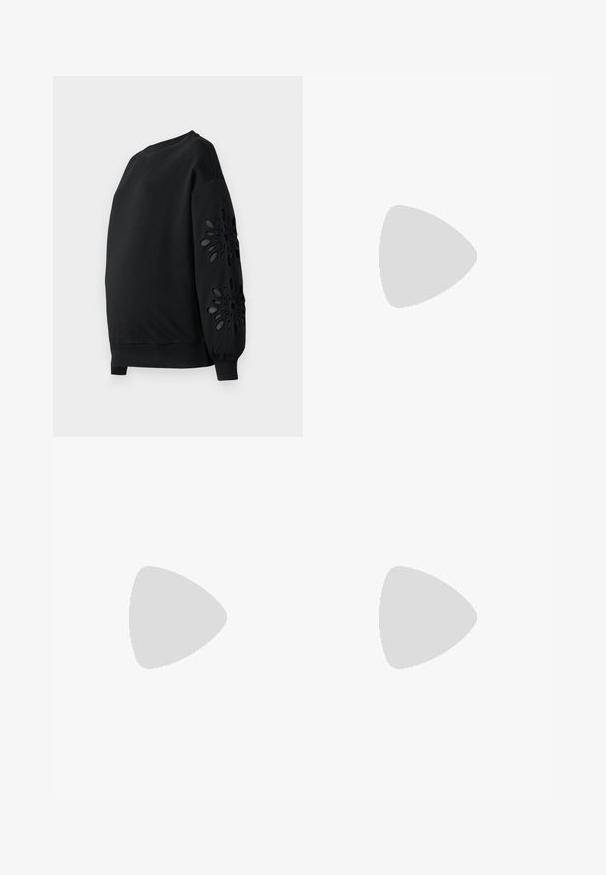 Sweatshirt noir à col rond et manches bouffantes, avec des motifs floraux découpés au laser sur les manches et une texture lisse.; Jupe maxi en imprimé léopard marron et noir, fabriquée en tissu doux, avec une taille à nouer et un design plissé pour une silhouette fluide.; Baskets blanches en matériau synthétique lisse, avec un bout arrondi, un design à lacets, une semelle plate et des détails perforés discrets.; Sac fourre-tout en suède brun avec une texture douce, présentant une seule bandoulière et une ouverture supérieure légèrement courbée. Aucun détail de matériel visible.