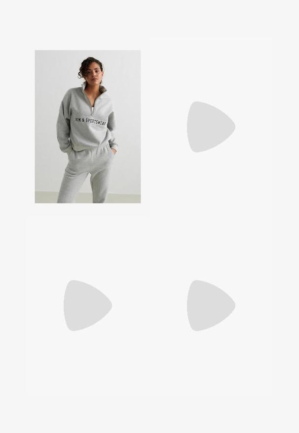 Szary sweter z suwakiem, z logo na środku. W zestawie z dopasowanymi szarymi spodniami dresowymi z elastycznym pasem.; Biała koszulka z krótkim rękawem o zaokrąglonym dole, z napisem "Juicy" ozdobionym kryształkami z przodu. Wykonana z miękkiej bawełny.; Czarne legginsy z wysokim stanem, teksturowana tkanina i dopasowany krój, zestawione z czarnymi butami sportowymi. Górna część ciała częściowo zakryta crop topem.; Białe, masywne sneakersy z teksturowaną cholewką, panelami z siateczki i grubymi gumowymi podeszwami o wyraźnym wzorze bieżnika. W zestawie sznurówki i pętla do zakupu.
