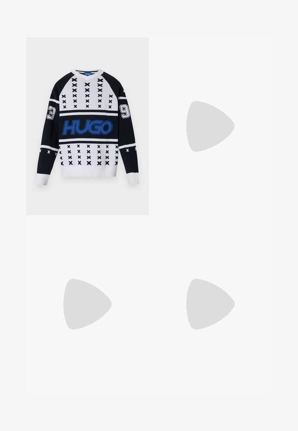 Fekete-fehér kötött pulóver geometrikus mintákkal, kiemelkedő kék logóval és számokkal díszített (3 és 9) az ujjakon. V nyakú kialakítás.; Hosszú ujjú fehér pamut ing kerek nyakkivágással, az alján oldalsó hasítékokkal és sima textúrával, hátulról bemutatva.; Világoskék farmernadrág, egyenes szárú fazonnal, öt zsebbel, gombos záródással, minimális kopással és kontrasztos varrással.; Fehér sportcipő sima bőr felső résszel és alacsony profilsal. Kerek orr, hat fűzőlyuk és barázdált gumitalp jellemzi.