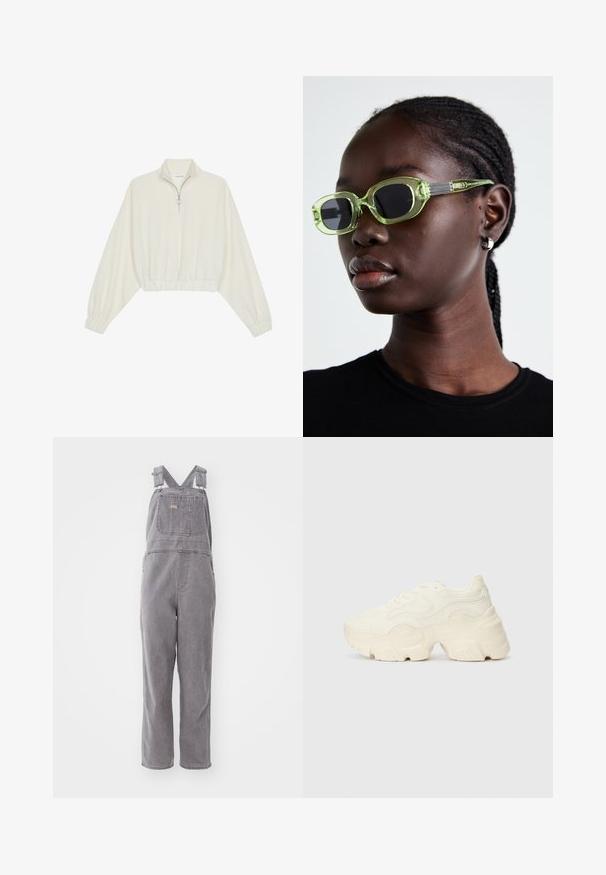 Skraćeni pulover od kremastog materijala, s visokim ovratnikom, zatvaranjem na polovicu munje, elastičnim rubom i manžetama, s glatkom teksturom i minimalnim dizajnom.; Sive traperice na bretele s podesivim naramenicama, prednjim džepom i opuštenim krojem. Ima ravne nogavice i jednoliku boju kroz cijelu šu.; Masivne bijele tenisice od teksturirane mreže i sintetičkih materijala, sa debelim potplatom i složenim uzorcima duž strana.; Zelene naočale s tankim, pravokutnim okvirom i tamnim lećama; teksturirane sive krake s brendingom. Glatka koža i crna majica.