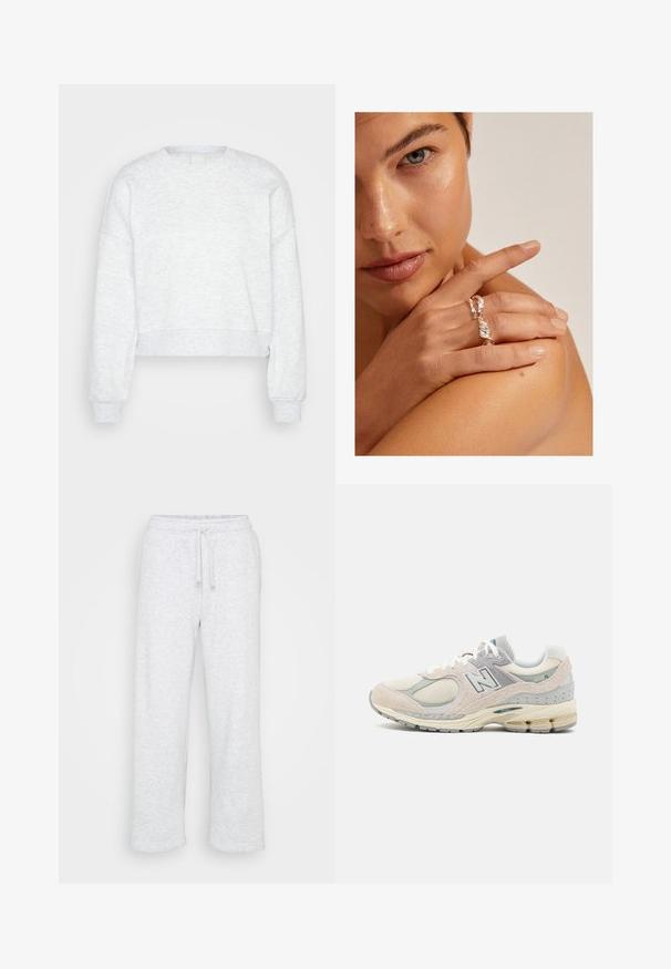 Lysegrå, langermet kort sweatshirt med ribbestrikkede mansjetter og høy crew-neck, vist på en ensfarget lys bakgrunn.; Lys grå bomullssweatpants med elastisk midje og snøring, rett benkutt, ingen synlige logoer eller mønstre.; Lys grå og beige New Balance-sneaker med semsket skinn og mesh-materiale, polstret krage, tykk såle og reflekterende detaljer. Snøringsdesign.; Sølvvridd ring med en teksturert design, båret på en hånd som hviler på en skulder. Hudtonen er varm med korte negler.