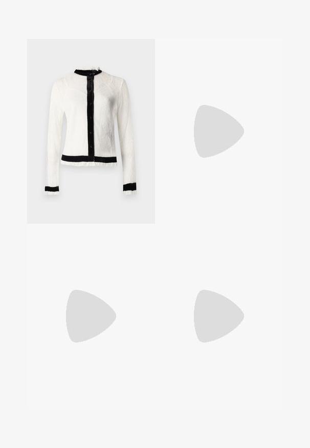Witte kanten blouse met lange mouwen en zwarte fluwelen kraag en knoopsluiting; heeft ruches aan de randen en een effen zwarte tailleband.; Zwarte flared broeken van rekbare stof met een gladde textuur en een aansluitende taille. Geen zichtbare sluitingen of patronen.; Zwarte leren enkellaars met zilveren oogjes, spitse neus en een blokhak. Slank ontwerp met een gladde textuur.; Zwarte leren handtas met een gebogen vorm, met een decoratief ontwerp aan de voorkant, een korte schouderband en accenten in goudkleurig beslag.