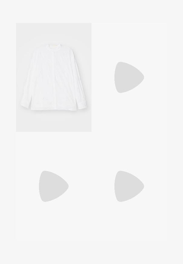 Erdem LONG SLEEVE OPEN BACK - Gombos blúz - white; Burgundi színű, selyem hatású, aszimmetrikus aljú rakott szoknya, amely puha redőzéssel és sima felülettel rendelkezik. Nincsenek látható zárások vagy minták.; Bézs színű magassarkú szandál fonott textúrával, díszítő virággal és bokapánttal. A négyzet alakú sarok stabilitást biztosít.; Göndör barna haj, világos bőrszín, arany fülbevalót visel. A háttér semleges szürke, a téma arcának jellemzőire összpontosít.