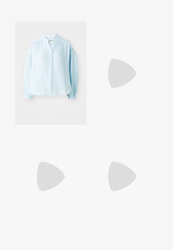 Chemise bleu clair à boutons, en tissu texturé, col rond, manches longues bouffantes, détails froncés le long de la patte de boutonnage et des poignets.; Pantalons droits en coton beige clair, avec une taille plate, des passants de ceinture, et sans poches ni motifs visibles.; Ballet plat métallisé argenté avec un bout pointu, une bride à la cheville avec boucle réglable, une surface texturée et une semelle noire minimaliste.; Boucles d'oreilles en argent présentant deux formes en goutte d'eau et deux formes arrondies, toutes avec une surface polie et réfléchissante et une texture lisse.