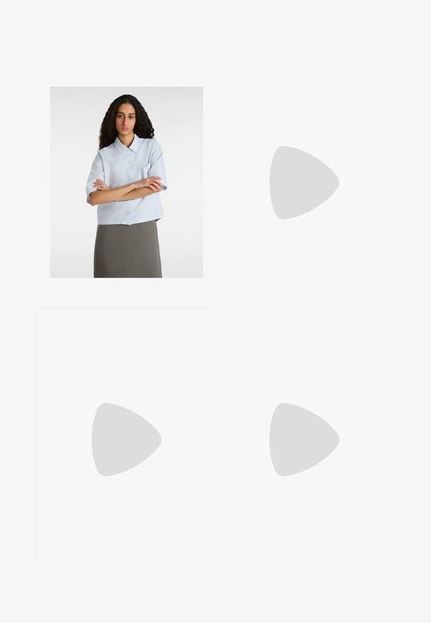 Camicia a maniche corte azzurro chiaro con colletto, apertura con bottoni e una tasca sul petto. Tessuto morbido, design cropped.; Jeans in denim a gamba larga di blu medio, con vita alta, chiusura con bottone e dettagli delle cuciture verticali a contrasto lungo la parte anteriore.; Sneakers beige con pannelli texturizzati crema e strisce marroni, abbinati a jeans in denim blu. I jeans hanno un taglio largo e orlo sfilacciato.; Borsa a tracolla nera in pelle con una forma curva, manico rimovibile e accessori dorati. La borsa presenta una patta con un dettaglio a fibbia.